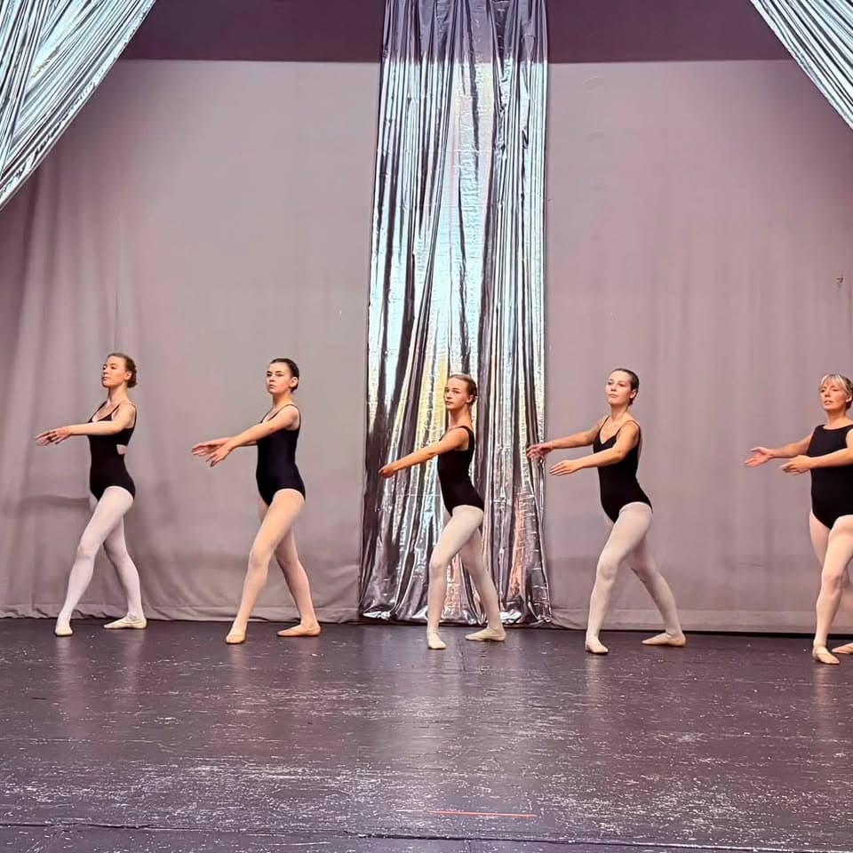 Ballet students of mixed ages in a line